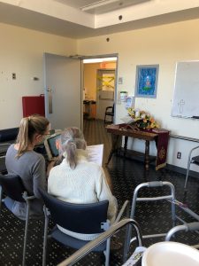An image of a care worker providing a one-on-one church service with an elderly patient